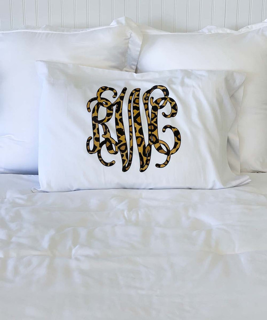 A monogrammed pillow case with leopard print